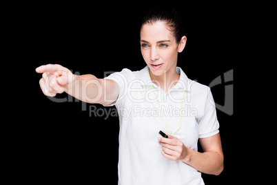 Female athlete blowing a whistle and pointing