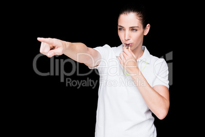 Female athlete blowing a whistle and pointing