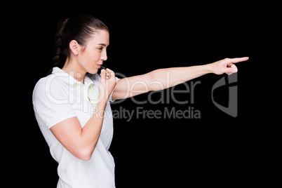 Female athlete blowing a whistle and pointing