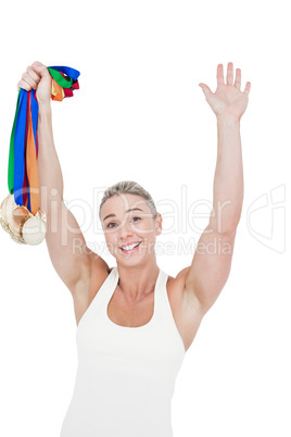 Happy female athlete holding medals