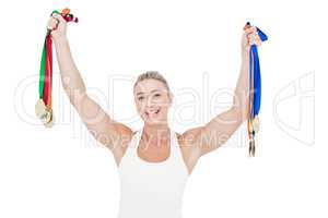 Happy female athlete holding medals