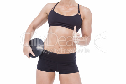 Female athlete holding discus and showing thumbs up