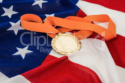 Close-up of gold medal on american flag