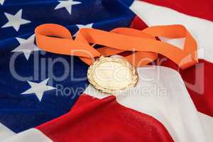 Close-up of gold medal on american flag