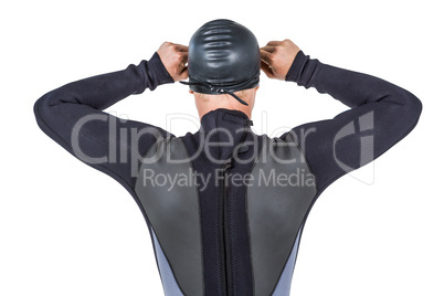 Rear view of swimmer in wetsuit wearing swimming goggles