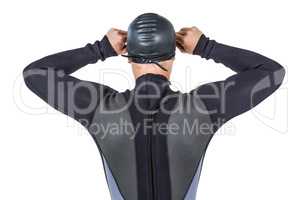 Rear view of swimmer in wetsuit wearing swimming goggles