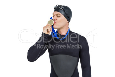 Swimmer kissing his gold medal