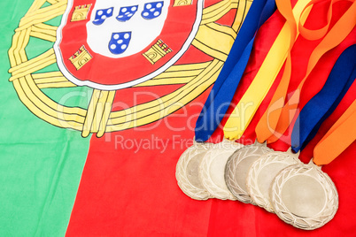 Close-up of gold medals on portuguese flag