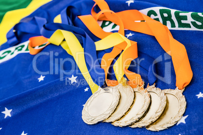 Close-up of gold medals on brazilian flag