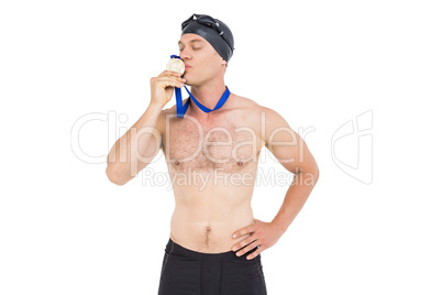 Swimmer kissing his gold medal