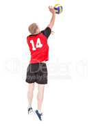 Rear view of sportsman hitting volleyball