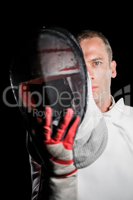 Close-up of swordsman holding fencing mask