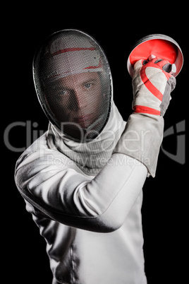 Close-up of man wearing fencing suit practicing with sword