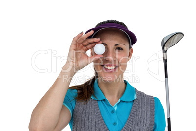 Golf player posing with a golf club and golf ball