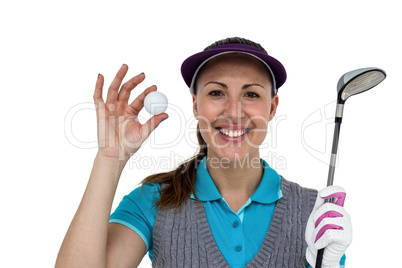 Golf player posing with a golf club and golf ball