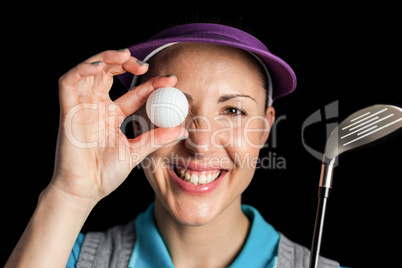 Golf player posing with a golf club and golf ball