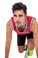 Confident athlete man in ready to run position