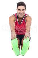 Portrait of male athlete doing stretching exercise