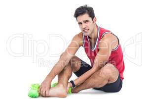 Portrait of male athlete with foot pain on white background