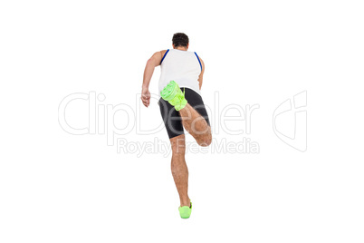 Rear view of male athlete running on white background