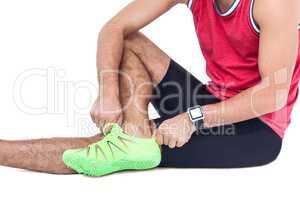 Male athlete wearing his sport shoes and getting ready for sport
