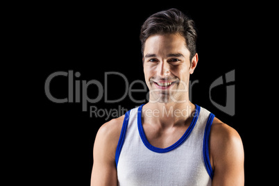 Portrait of happy athlete on black background