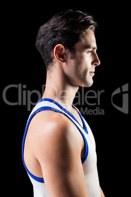 Side view of male athlete on black background