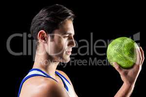 Confident athlete man holding a ball