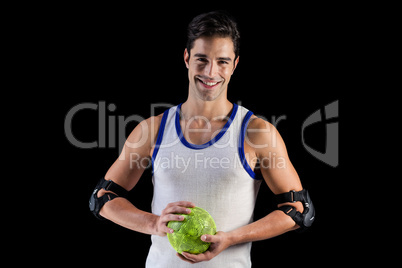 Portrait of happy athlete man holding a ball