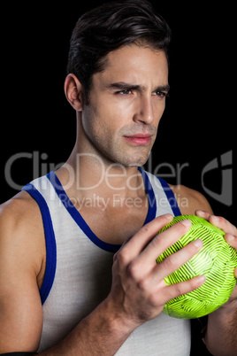 Confident athlete man holding a ball