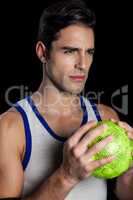 Confident athlete man holding a ball