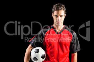 Portrait of confident male athlete holding football