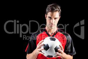 Portrait of confident male athlete holding football