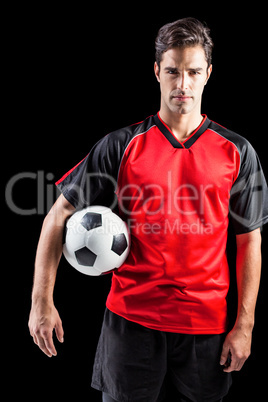 Portrait of confident male athlete holding football