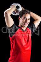 Portrait of happy male athlete throwing football