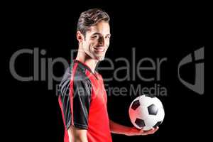 Portrait of happy male athlete holding football