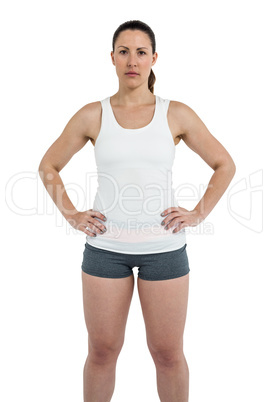 Portrait of female athlete standing with hands on hips