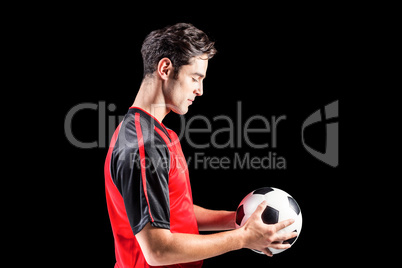 Confident male athlete holding football Confident male athlete holding football