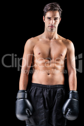 Portrait of boxer standing on black background