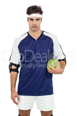 Sportsman standing with ball on white background