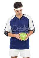 Sportsman standing with ball on white background