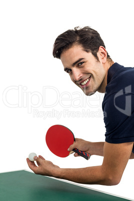 Portrait of happy male athlete playing table tennis