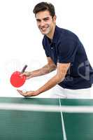 Portrait of male athlete playing table tennis