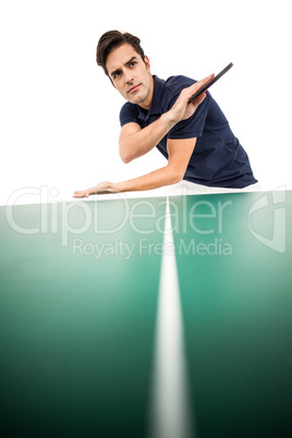 Confident male athlete playing table tennis