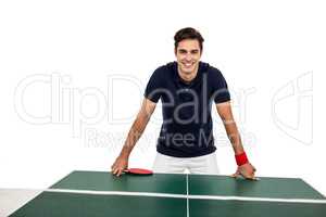 Confident male athlete leaning on hard table