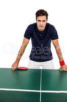 Confident male athlete leaning on hard table