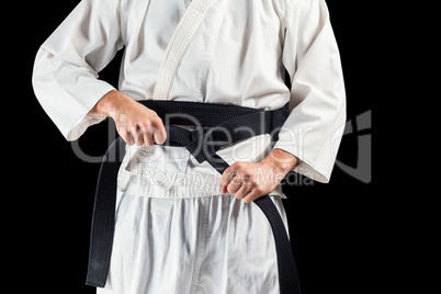 Mid section of fighter tightening karate belt