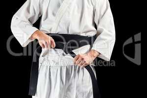 Mid section of fighter tightening karate belt