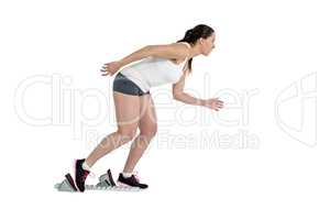 Confident athlete woman running from starting blocks