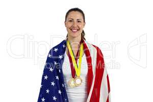 Athlete posing with american flag and gold medals around his nec